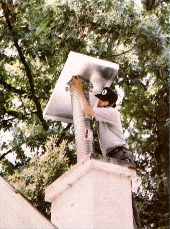 Installing the weather-sealing, stainless steel cap on a Ventinox relined chimney.